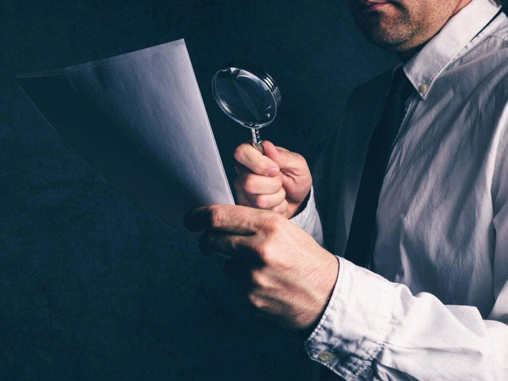 Man inspecting sheet of paper; sanctions against UHY